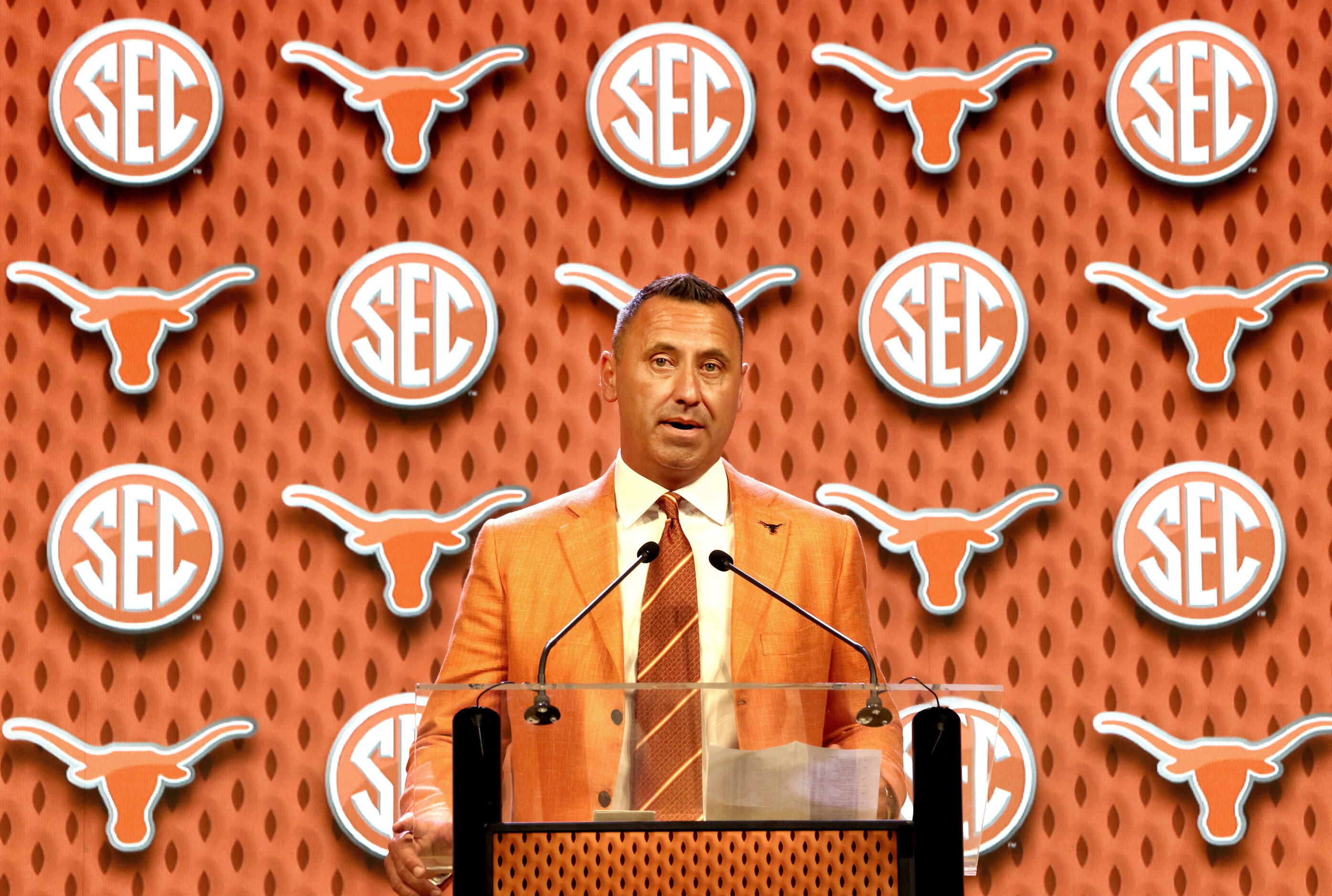 Juxtaposed with the longhorn logo, Texas head coach Steve Sarkisian speaks on preparations...