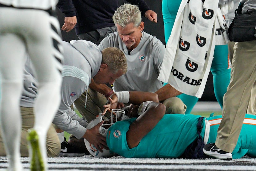 FILE - Miami Dolphins quarterback Tua Tagovailoa is examined during the first half of the...