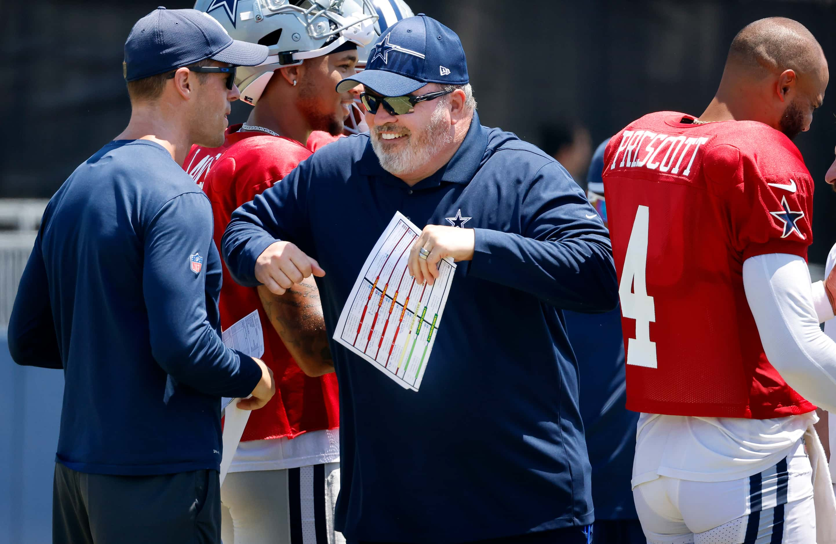 Dallas Cowboys head coach Mike McCarthy  bumps his assistant as they break a post training...