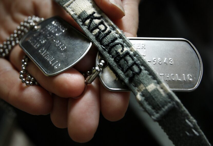 Kristy Kruger holds her brother Lt. Col. Eric Kruger's dog tags and helmet band after he...