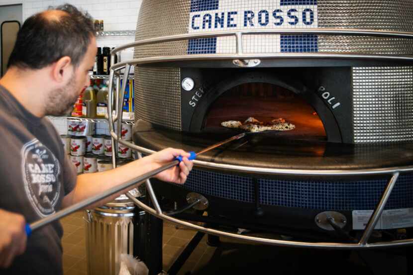 Order a pizza and a pizzaiolo will pull it out of Dallas Cowboys helmet-shaped oven at Cane...