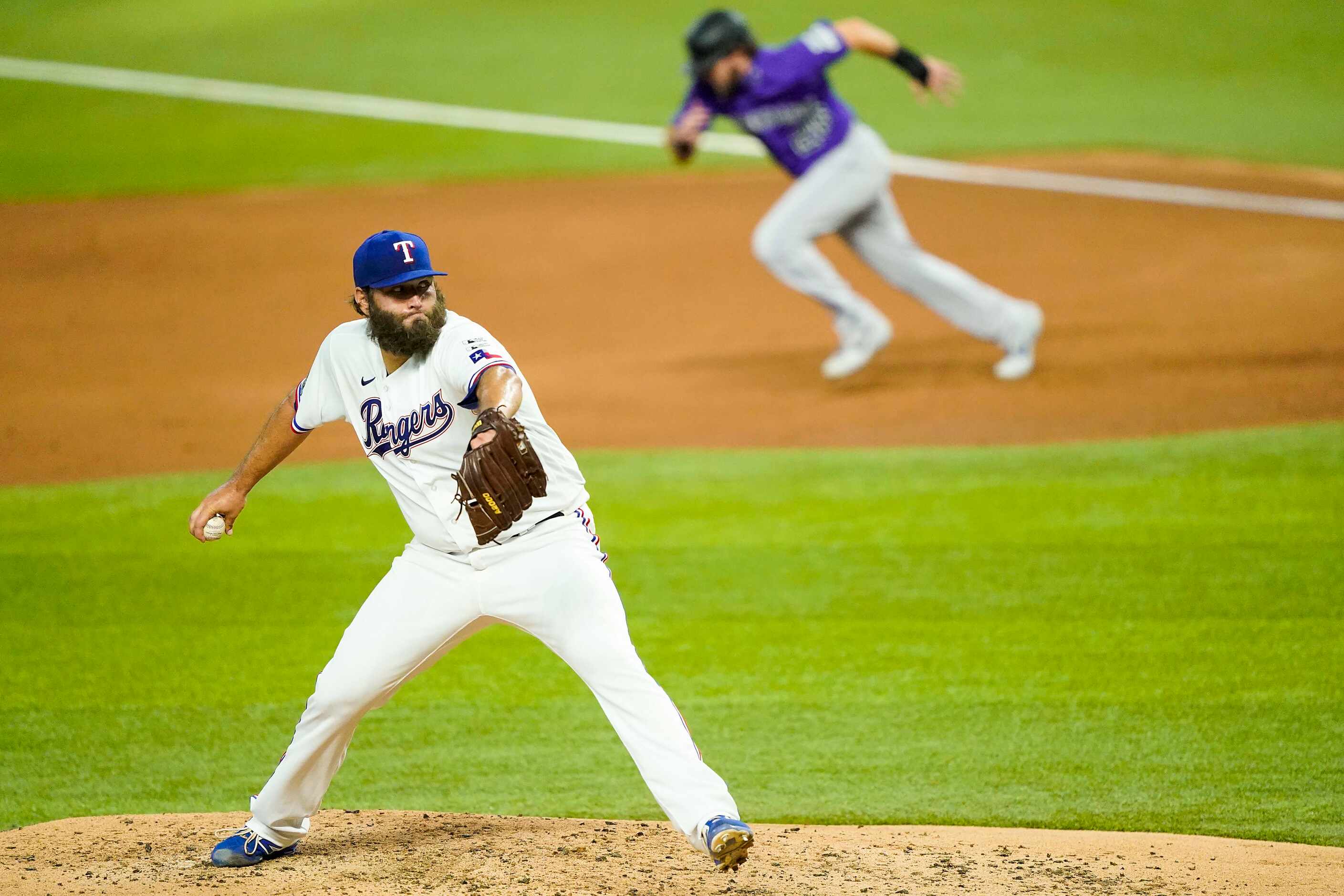 Texas Rangers pitcher Lance Lynn pitches as Colorado Rockies center fielder David Dahl takes...