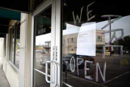 A handwritten sign tells Starbucks customers they are open, despite the fact that the dining...