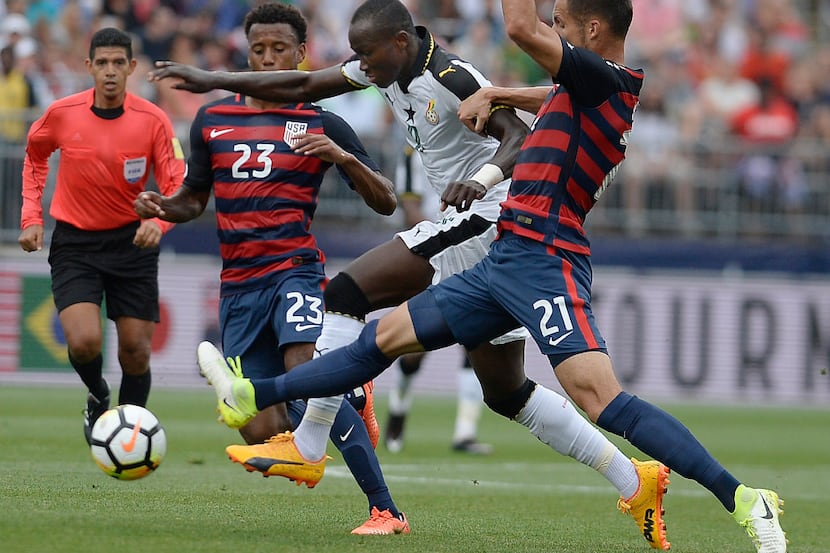 United States' Kellyn Acosta, left, and Matt Hedges, right, pressure Ghana's Raphael...