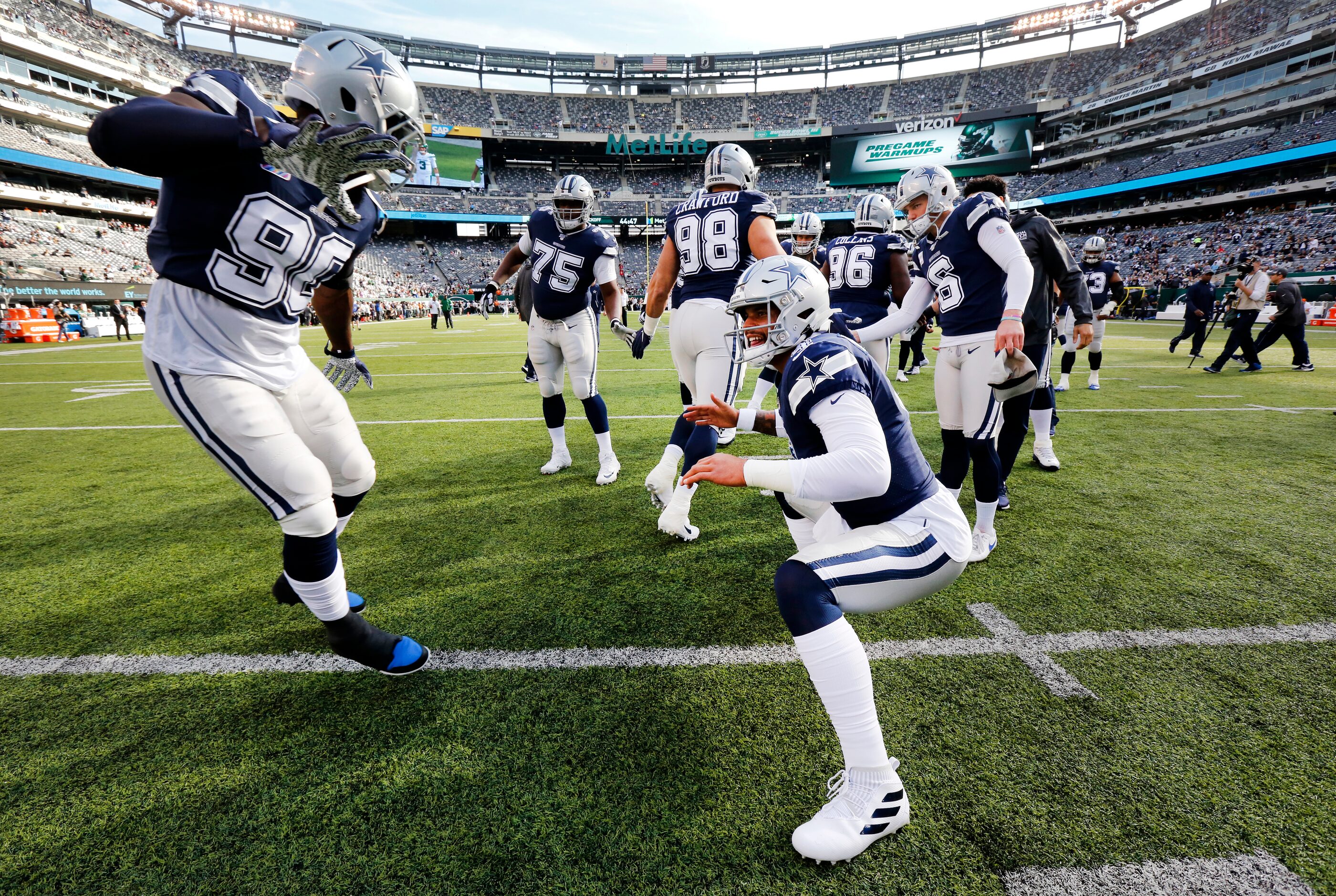 Dallas Cowboys defensive end Demarcus Lawrence (90) slaps hands with Dallas Cowboys...