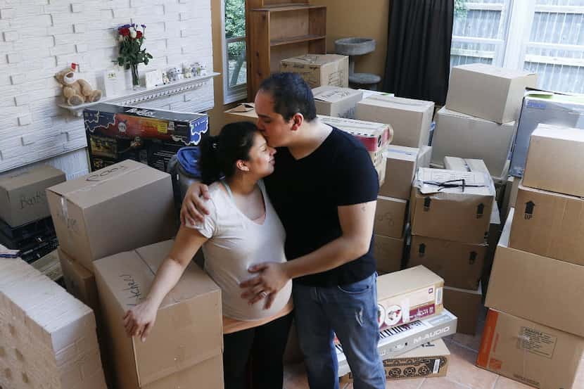 Jacob and Amanda Gallegos stand amongst their boxes after moving into their new home in...