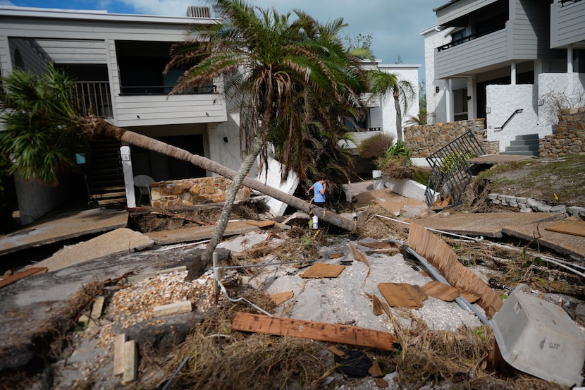 A person picks their way along damaged walkways in the beachfront condominium community of...