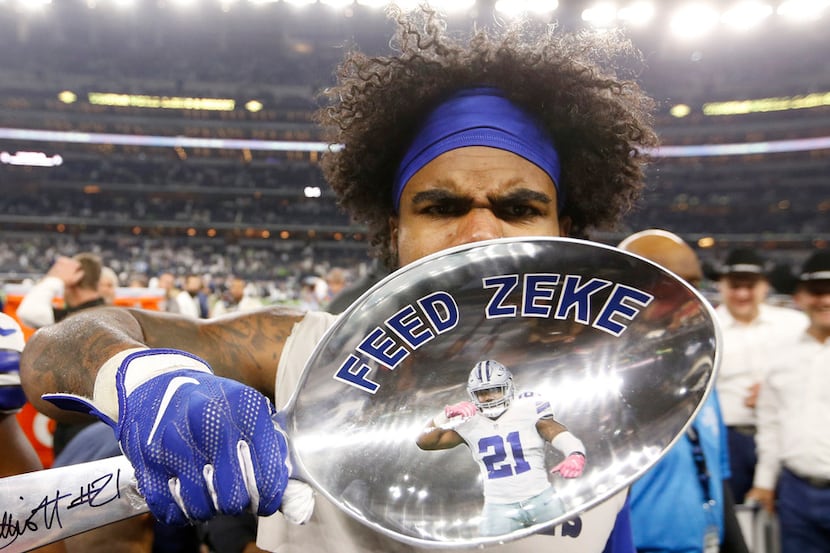 Dallas Cowboys running back Ezekiel Elliott (21) gestures his feed me after signing a giant...