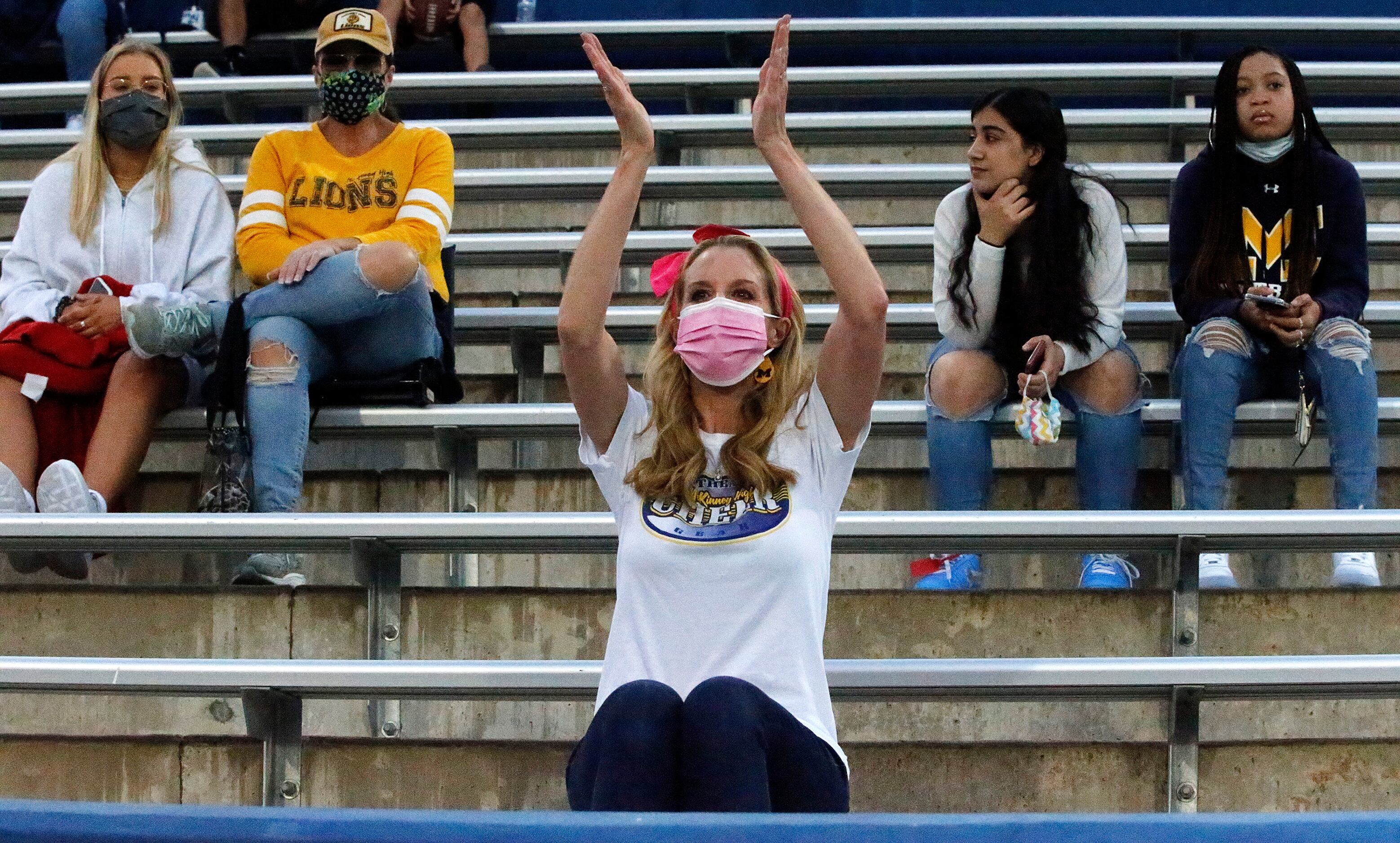 McKinney resident Cindy Philosfsky (center) dons a mask and practices social distancing as...