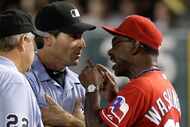 Texas Rangers' Ron Washington argues with first base coach Angel Hernandez, center, and crew...