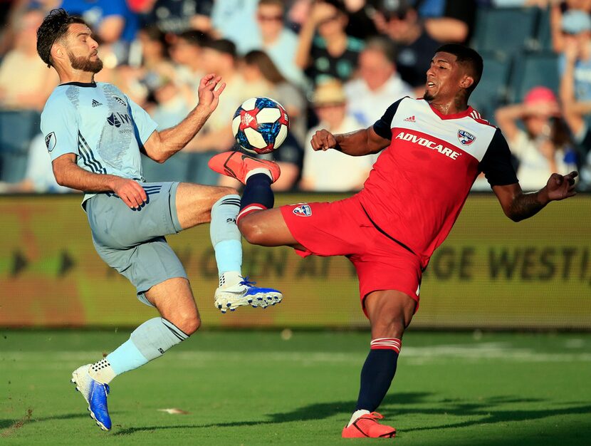 Sporting Kansas City midfielder Graham Zusi, left, challenges FC Dallas midfielder Santiago...