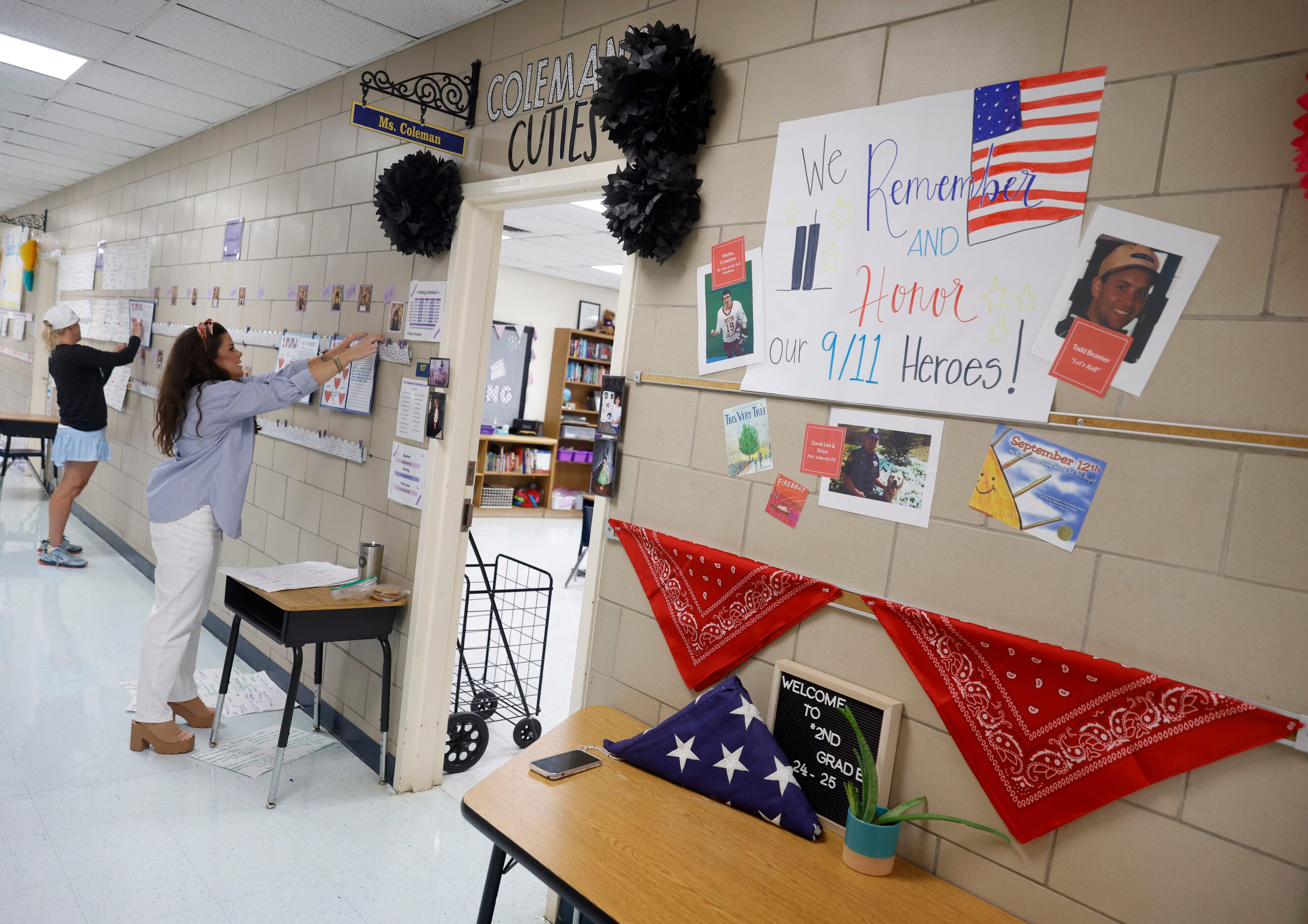 Second grader teacher Katie Coleman (right) and parent volunteer Lisa Camp hang students...