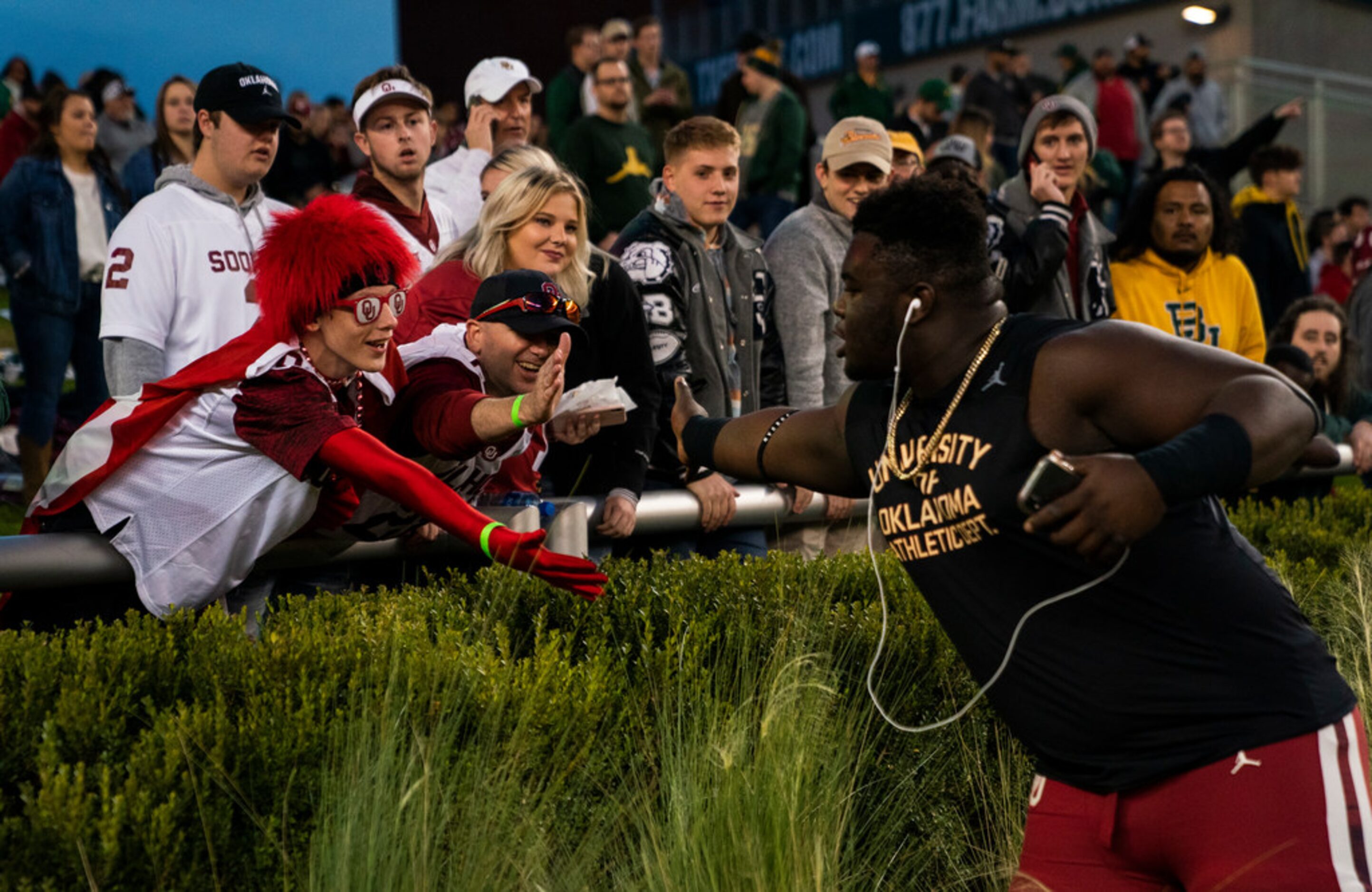 An Oklahoma Sooners player greets fans before an NCAA football game between Baylor...