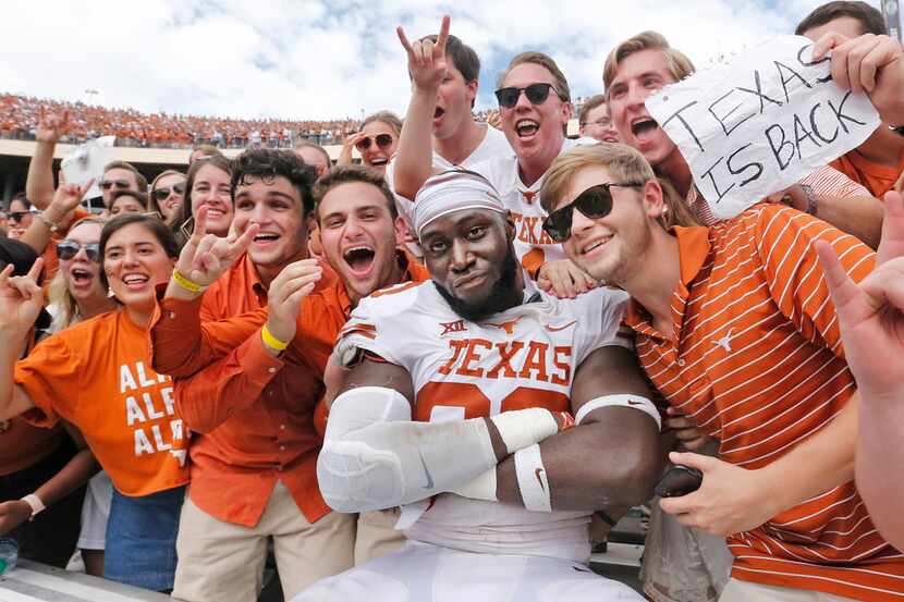 Texas Longhorns defensive lineman Charles Omenihu (90) poses with fans after the Longhorns'...