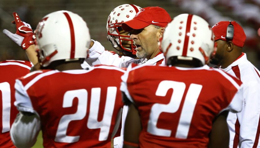 TXHSFB Terrell head coach Mike Shields talks to his team as Deshon Patterson (24) and...