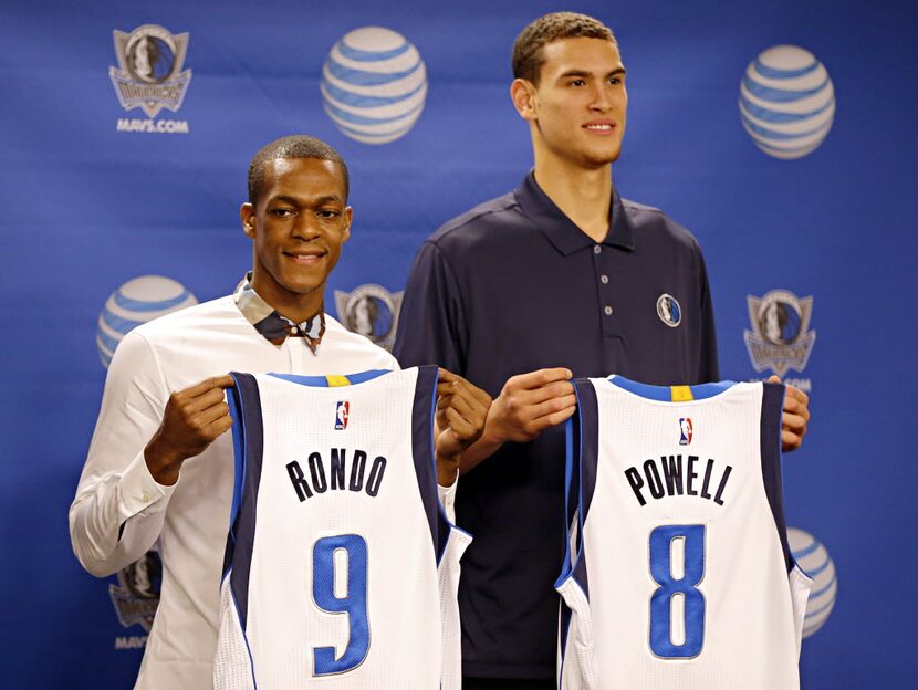 Rajon Rondo (left) and Dwight Powell hold their new Dallas Mavericks jerseys during a press...