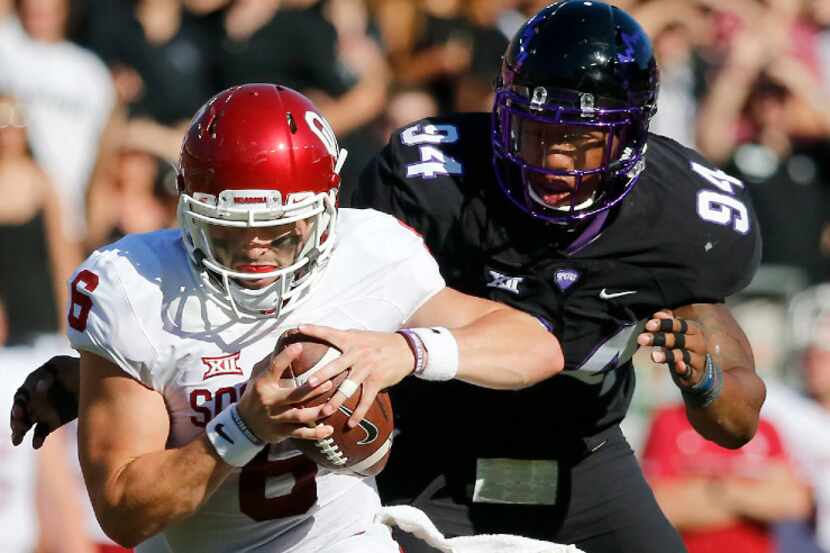 Oklahoma quarterback Baker Mayfield (6) is chased by TCU defensive end Josh Carraway during...