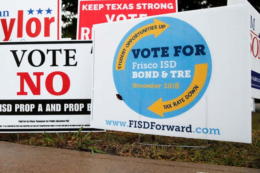 Signs for and against the Frisco ISD bond and tax ratification election outside a polling...