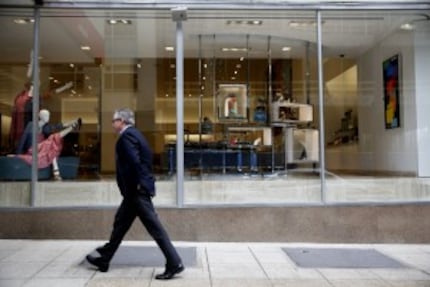  A man walks past the women's shoe department storefront window of Neiman Marcus in downtown...