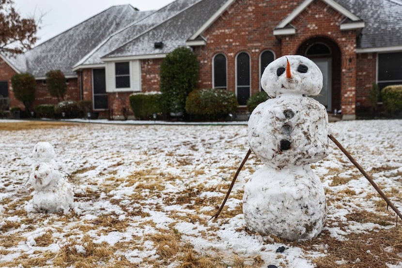 Two snowmen stand tall in front of a house in Red Oak as winter weather passes through North...