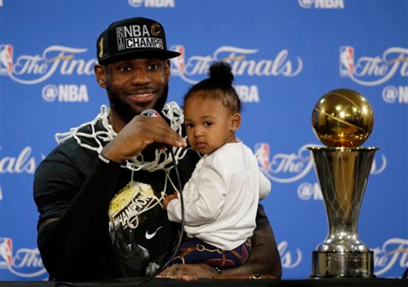 En esta foto de archivo del 19 de junio de 2016, el basquetbolista LeBron James sostiene a...