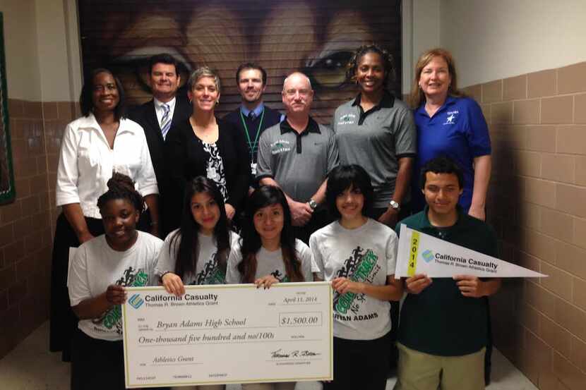 Members of the Bryan Adams track and cross country teams pose with a commemorative check...