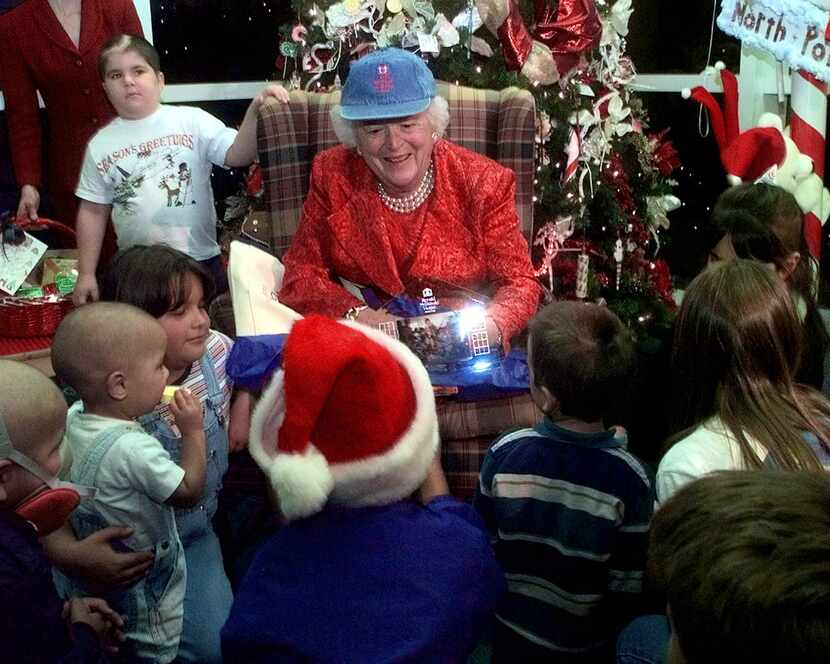 Former first lady Barbara Bush shows the children of Ronald McDonald's House a photo after...