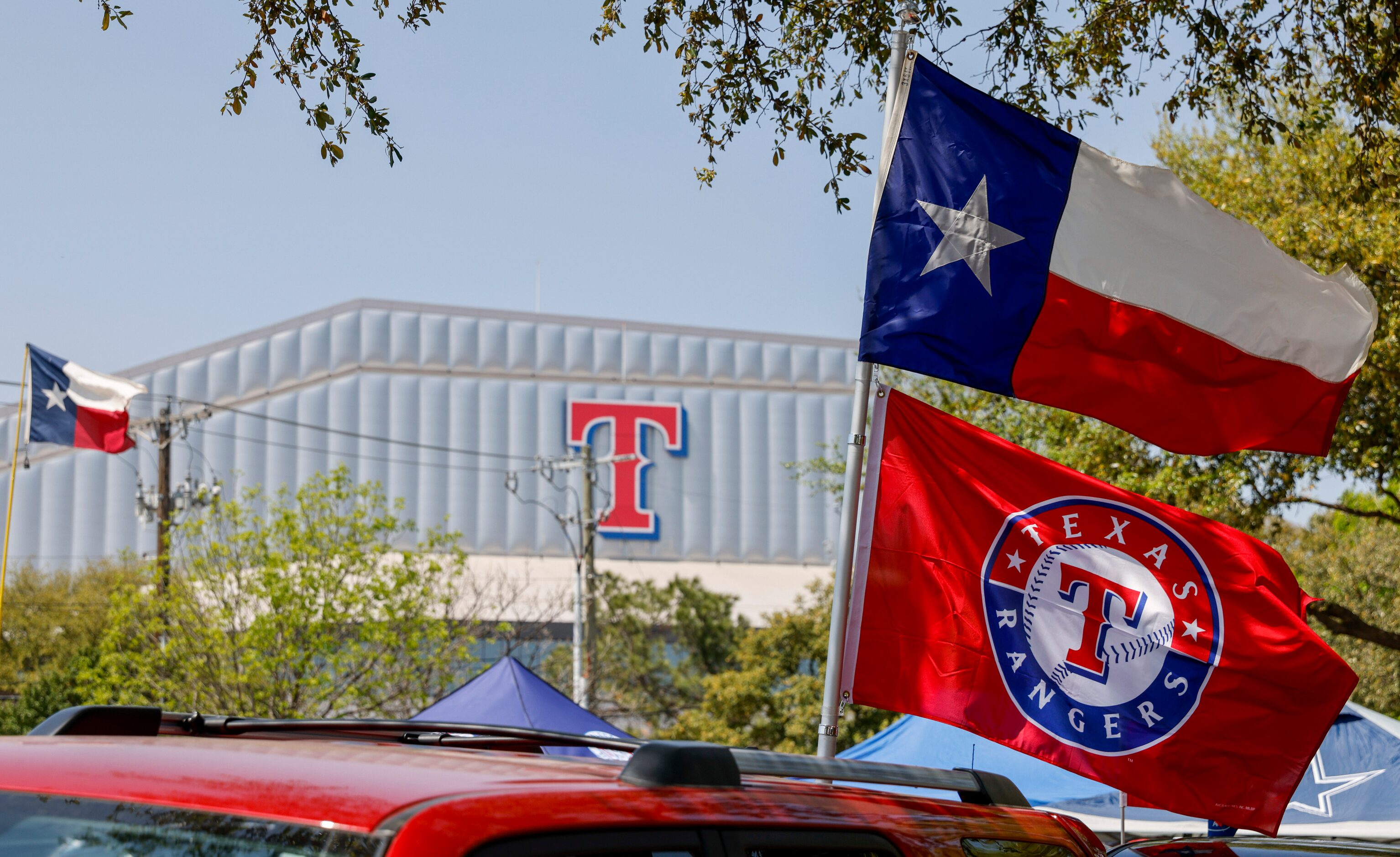 A Texas flag flies above a Texas Rangers flag before the home opener against the Colorado...