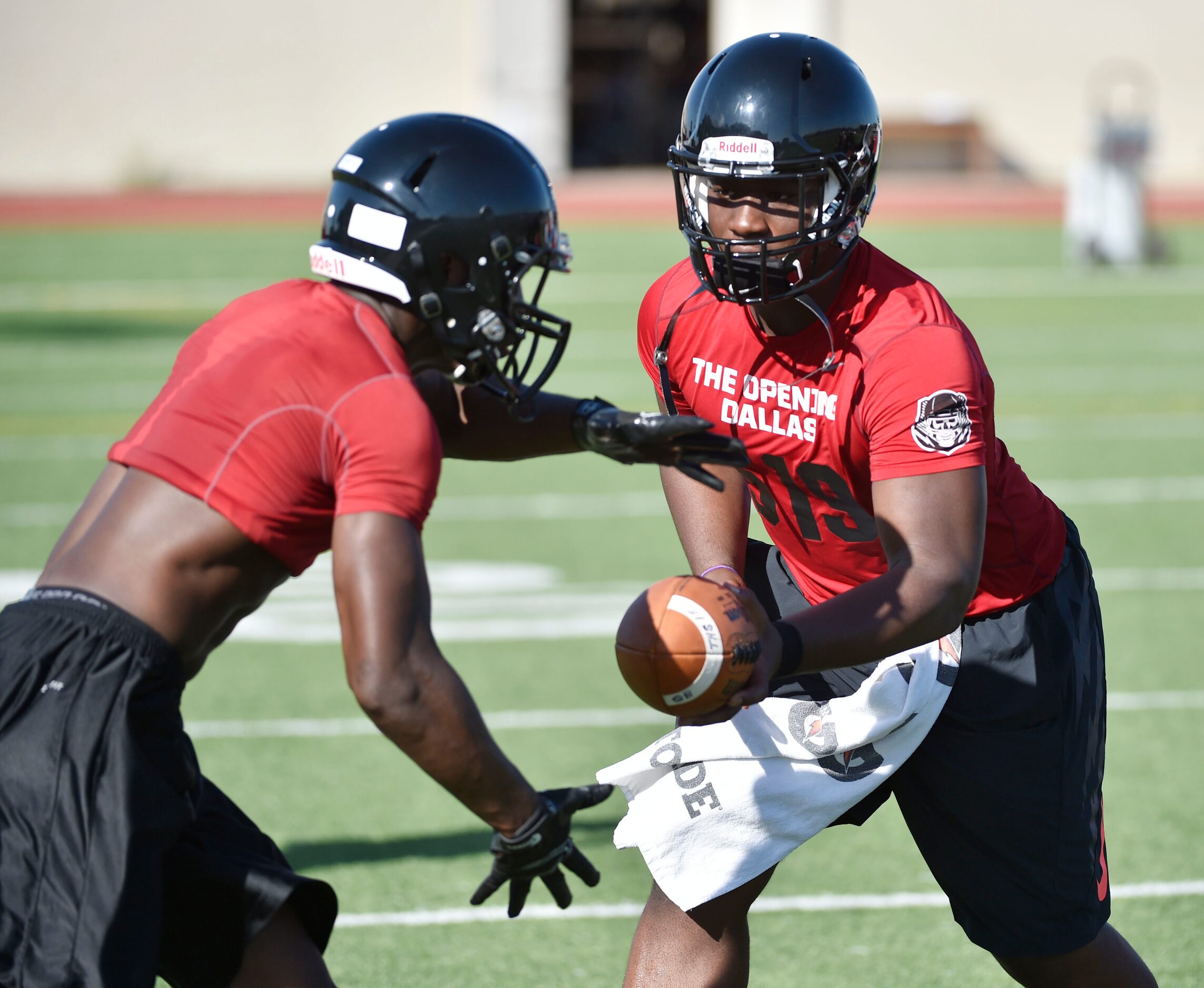 Trinity quarterback Tyler Natee, right, hand the ball off to  running back Ja'Ron Wilson,...