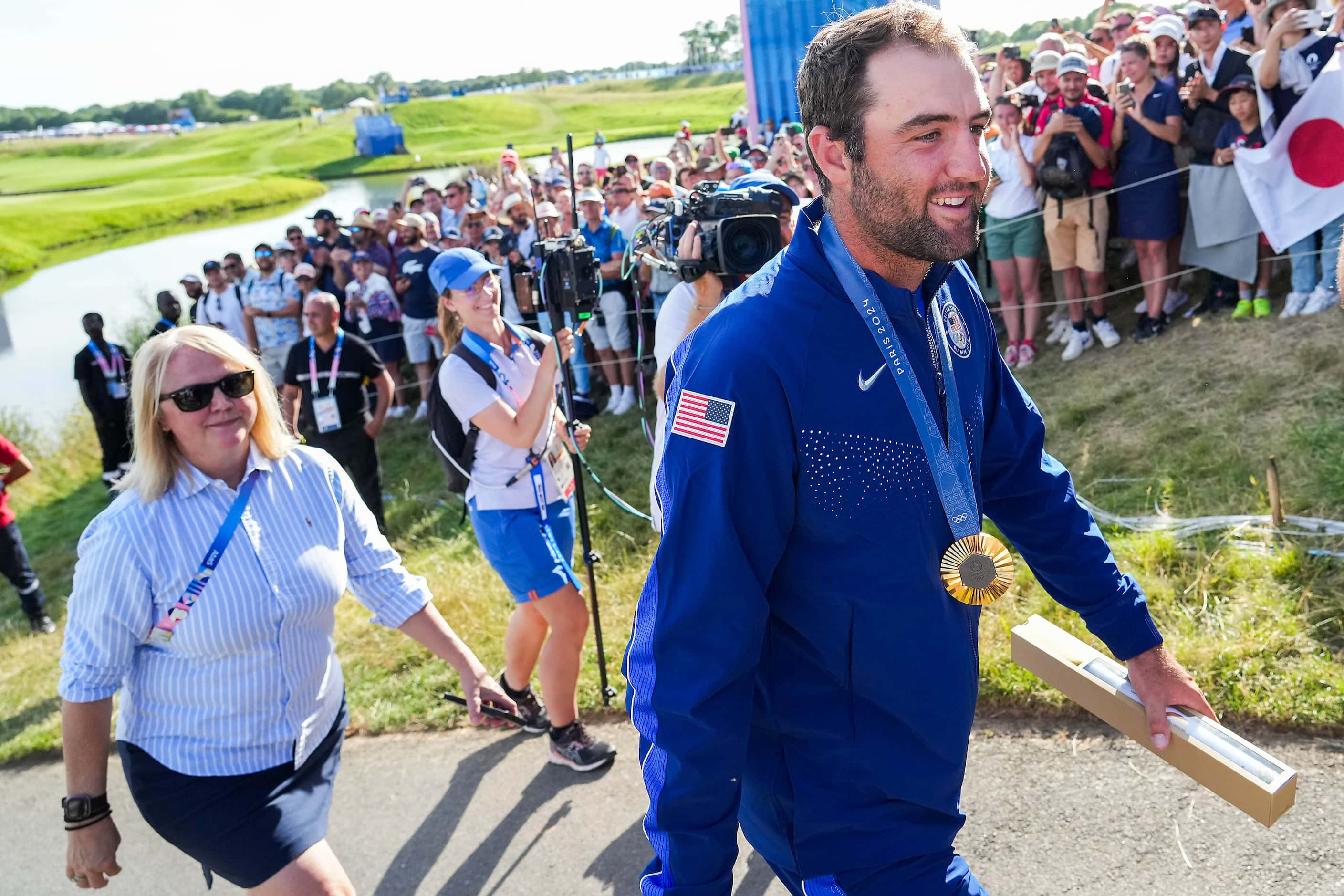 Fans cheer gold medalist Scottie Scheffler of the United States following the medal ceremony...