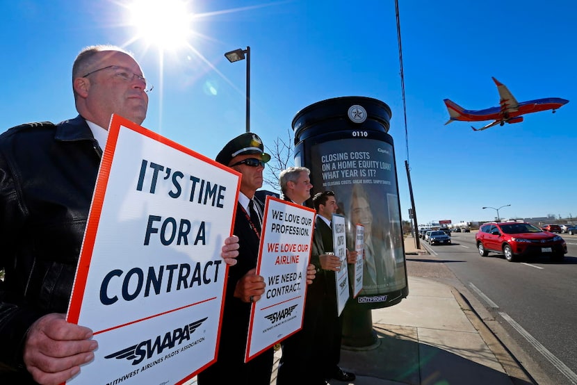  Southwest Airlines pilots hold signs to protest drawn-out contract negotiations in Dallas...