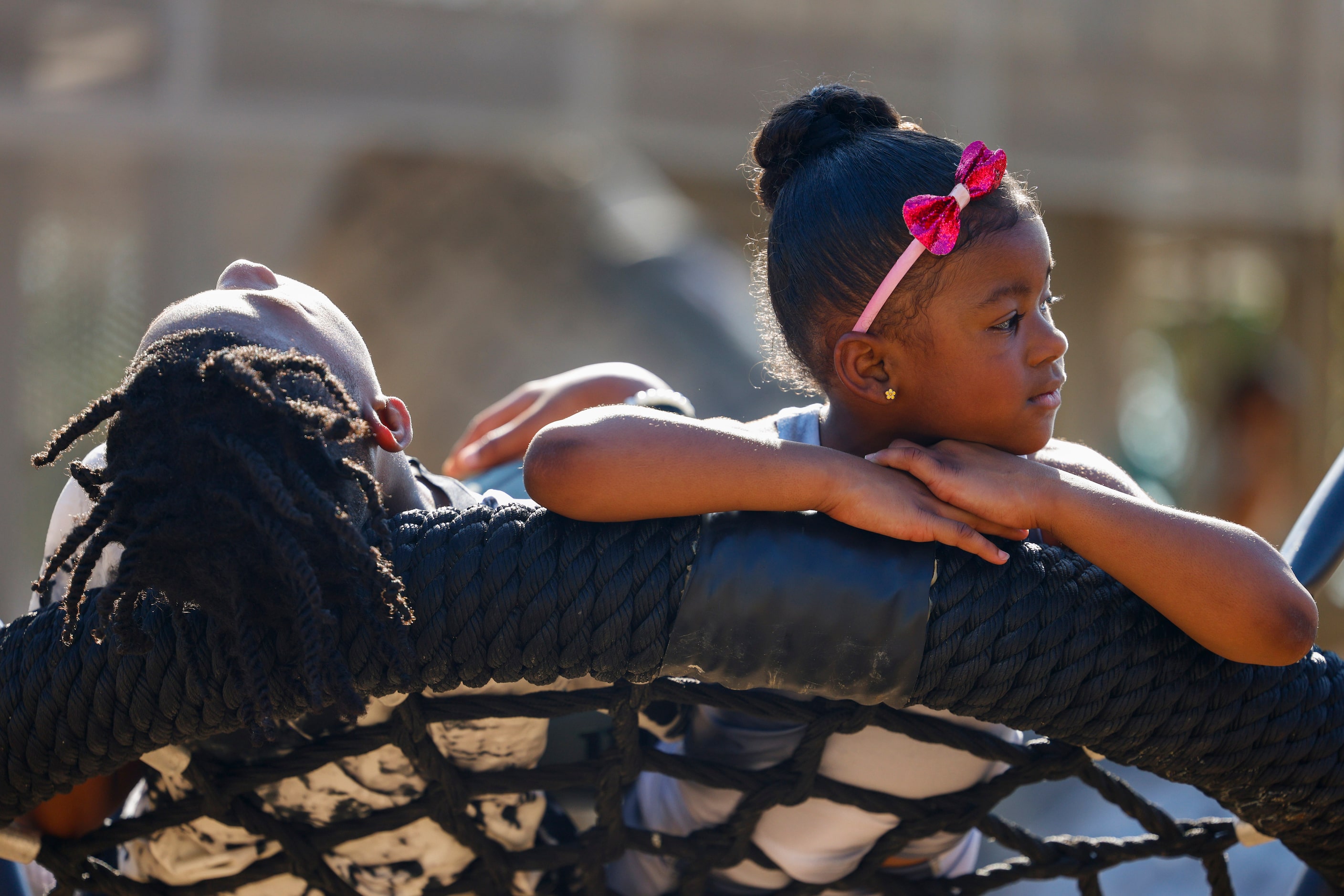 Ashton Gipson, 11, (left), relaxes as Aliyah Strange 4, looks away on the swing during the...