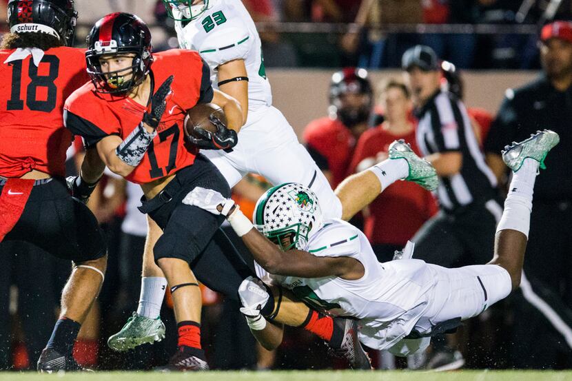 Euless Trinity wide receiver Colby Parton (17) is tackled by Southlake Carroll defensive...