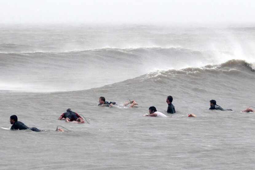 
Surfers waited for the next wave Sunday in Galveston. Drenching storms finally cleared...