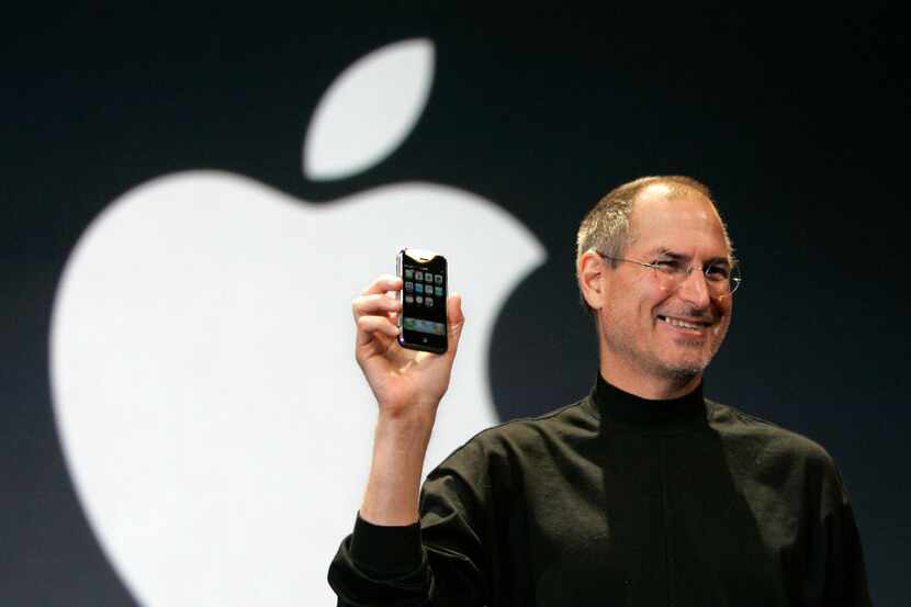 Apple CEO Steve Jobs holds up the new iPhone during his keynote address at MacWorld...