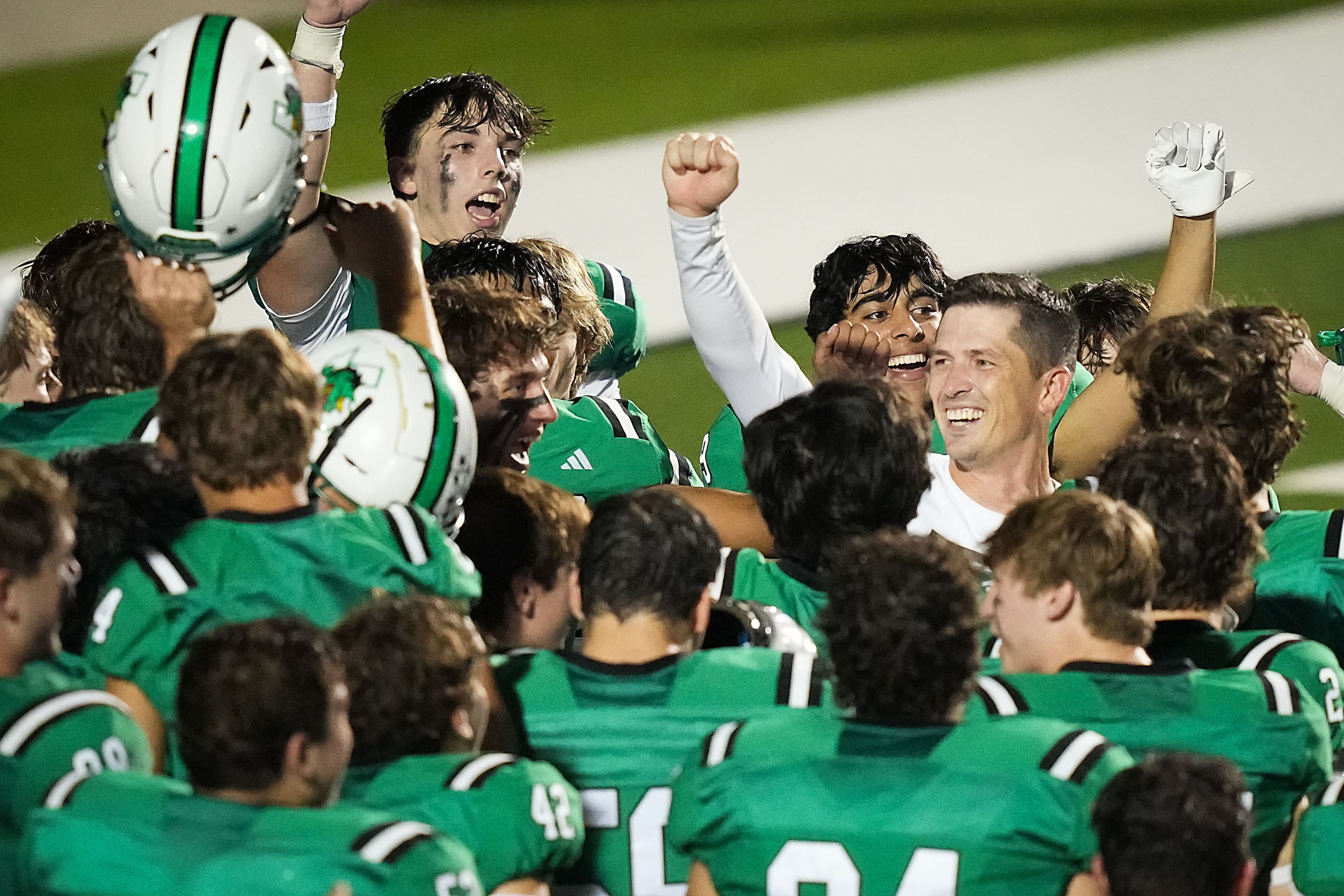 Southlake Carroll head coach Riley Dodge celebrates with his players after a 33-21 victory...