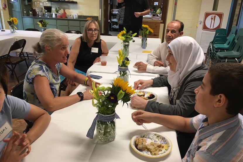 Members of the Arapaho United Methodist Church congregation share a meal with the Fajer family.