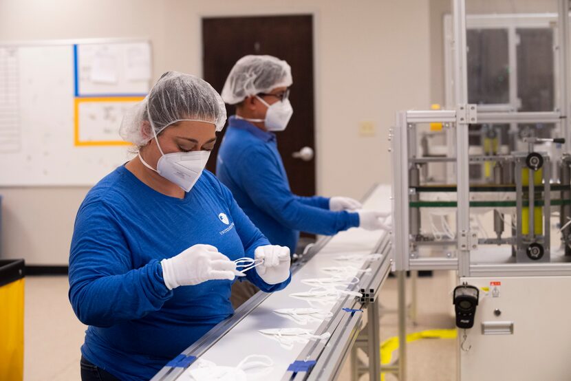 Production specialists Cassandra Medina, left, and Rong Tran inspect KID95 masks on the...