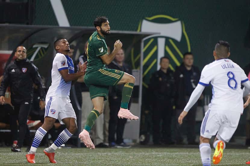 Portland Timbers' Diego Valeri (8) jumps for the ball between Dallas FC players, including...