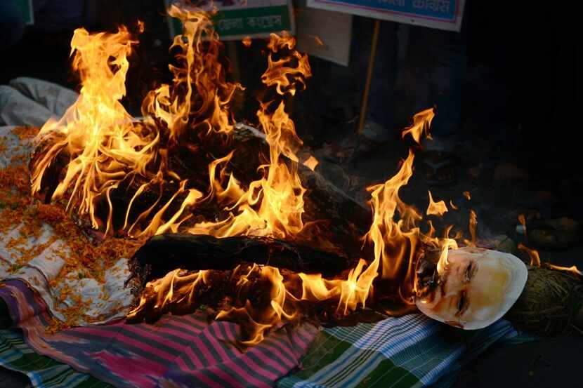 Indian members of the Congress Party burn an effigy of Prime Minister Narendra Modi during a...
