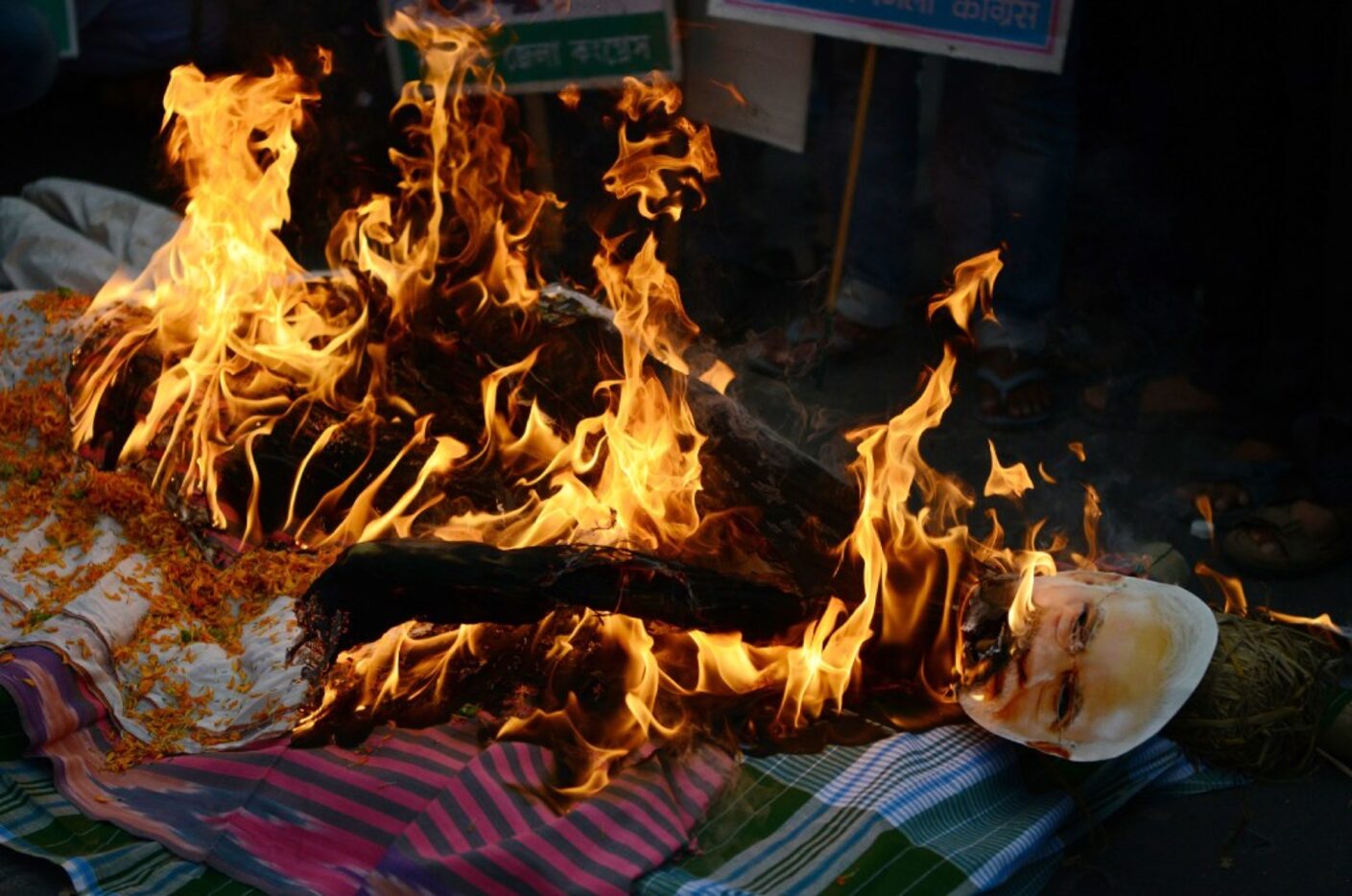 Indian members of the Congress Party burn an effigy of Prime Minister Narendra Modi during a...