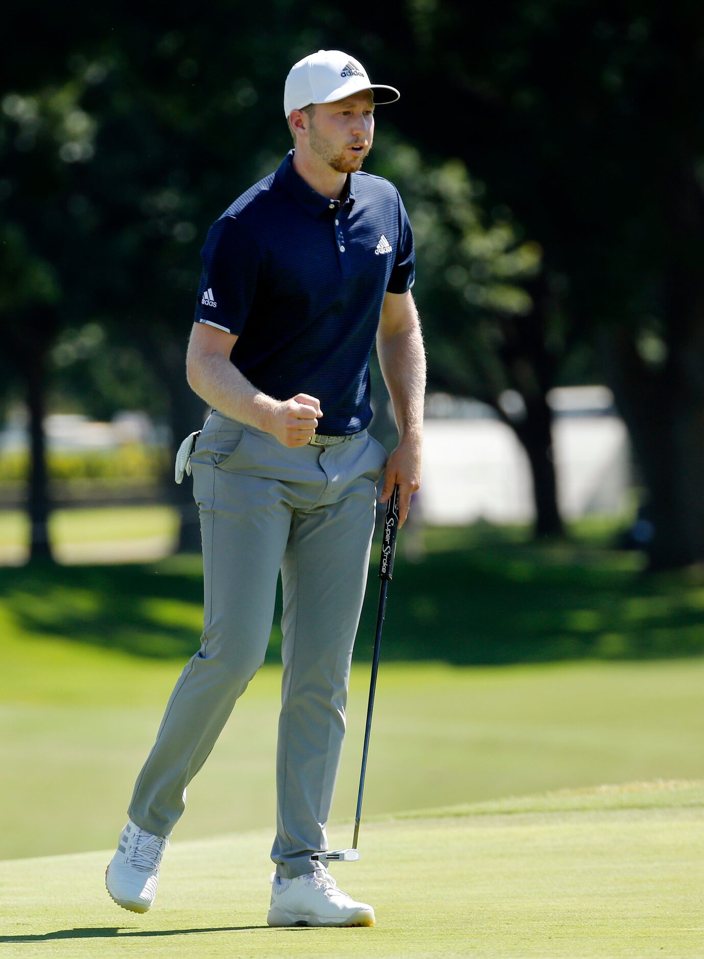 PGA Tour golfer Daniel Berger pumps his fist as he hit a birdie putt on No. 18 to make a...