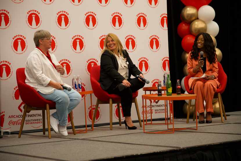 Three women employees from Coca-Cola Southwest Beverages set on a stage with red and white...