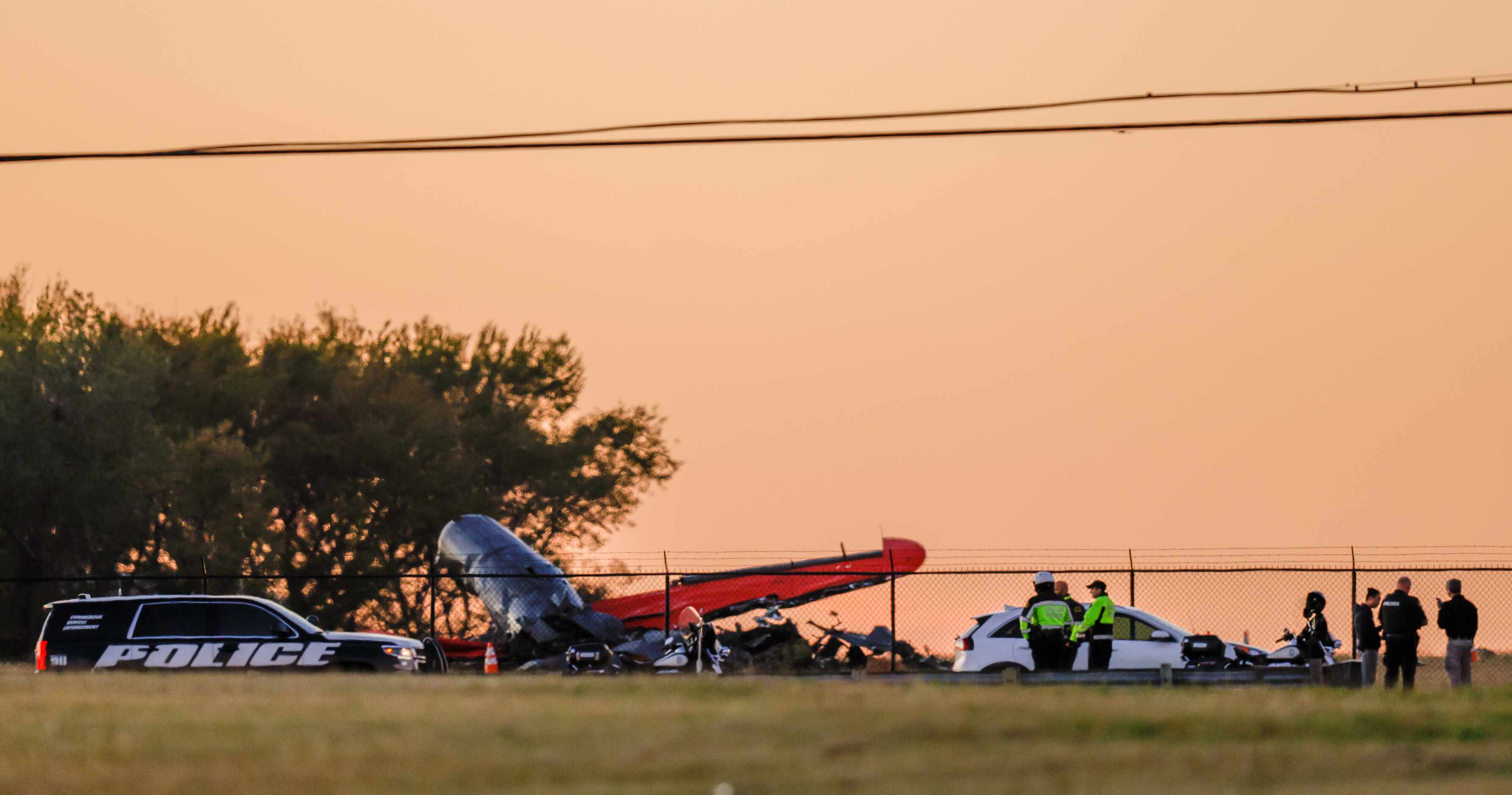 The sun begins to set over the damage from a mid-air collision between two planes that sits...