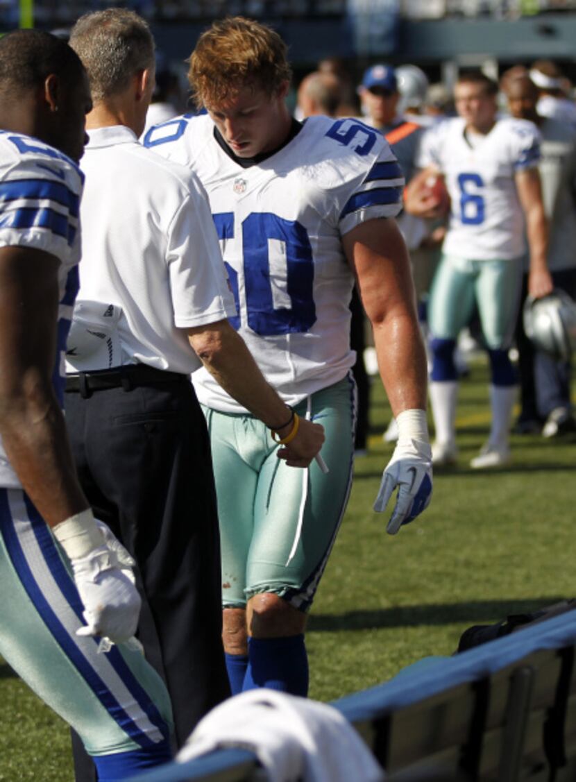 Dallas Cowboys inside linebacker Sean Lee (50) is checked on by medical staff after getting...