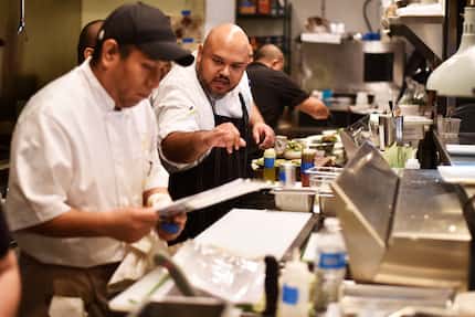 Executive Chef Jose Salmeron instructs his assistants while preparing food at the new...