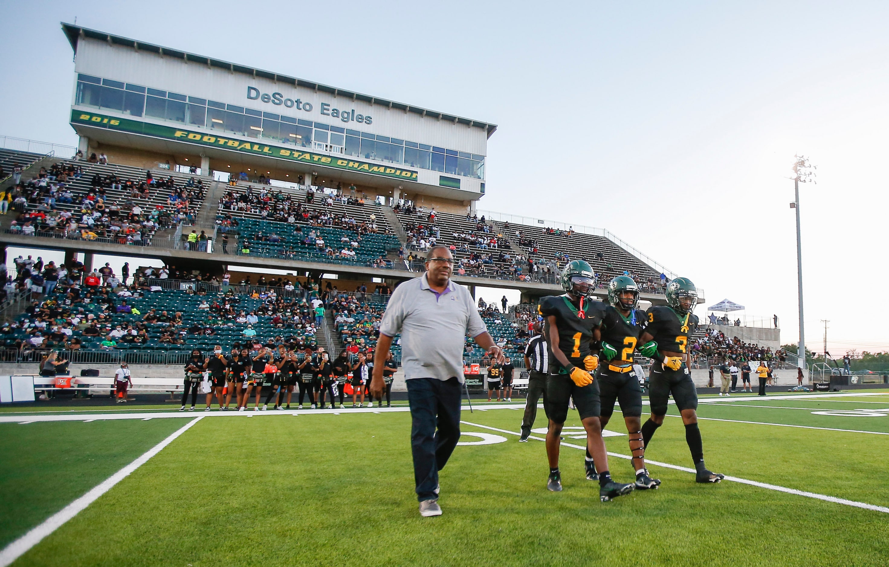 State Senator Royce West, left, walks to center field with DeSoto junior wide receiver...