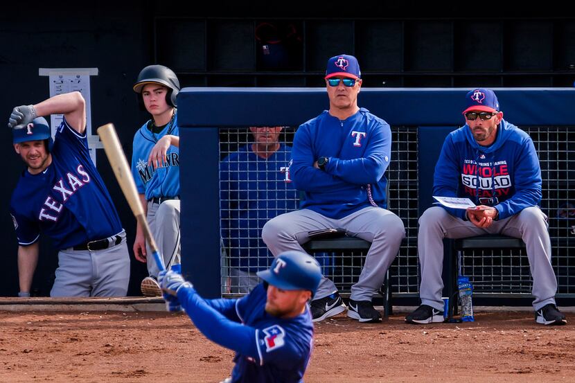 Texas Rangers bench coach Don Wakamatsu (center) and manager Chris Woodward (right) watch...