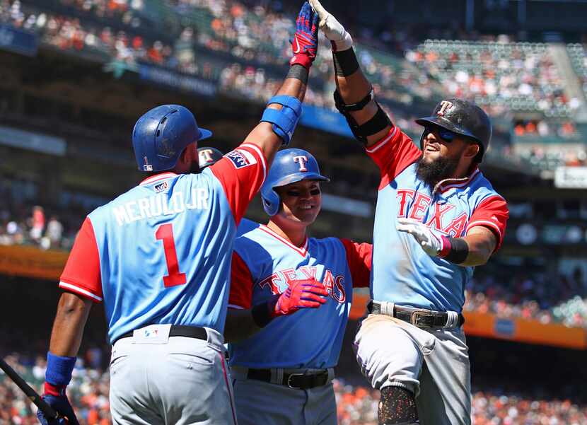 Texas Rangers' Rougned Odor, right, celebrates with Shin-Soo Choo, center, and Elvis Andrus...