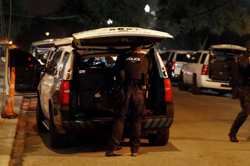 Dallas SWAT officers return to their vehicles after an hours-long incident in which they...